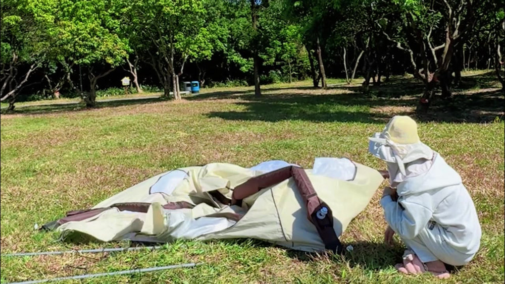 Camper rolling the deflated LINKSOLAR inflatable tent toward the valve